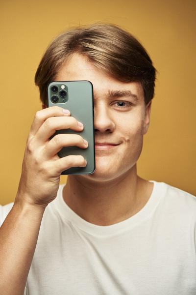 Dreng holder mobiltelefon for øjet